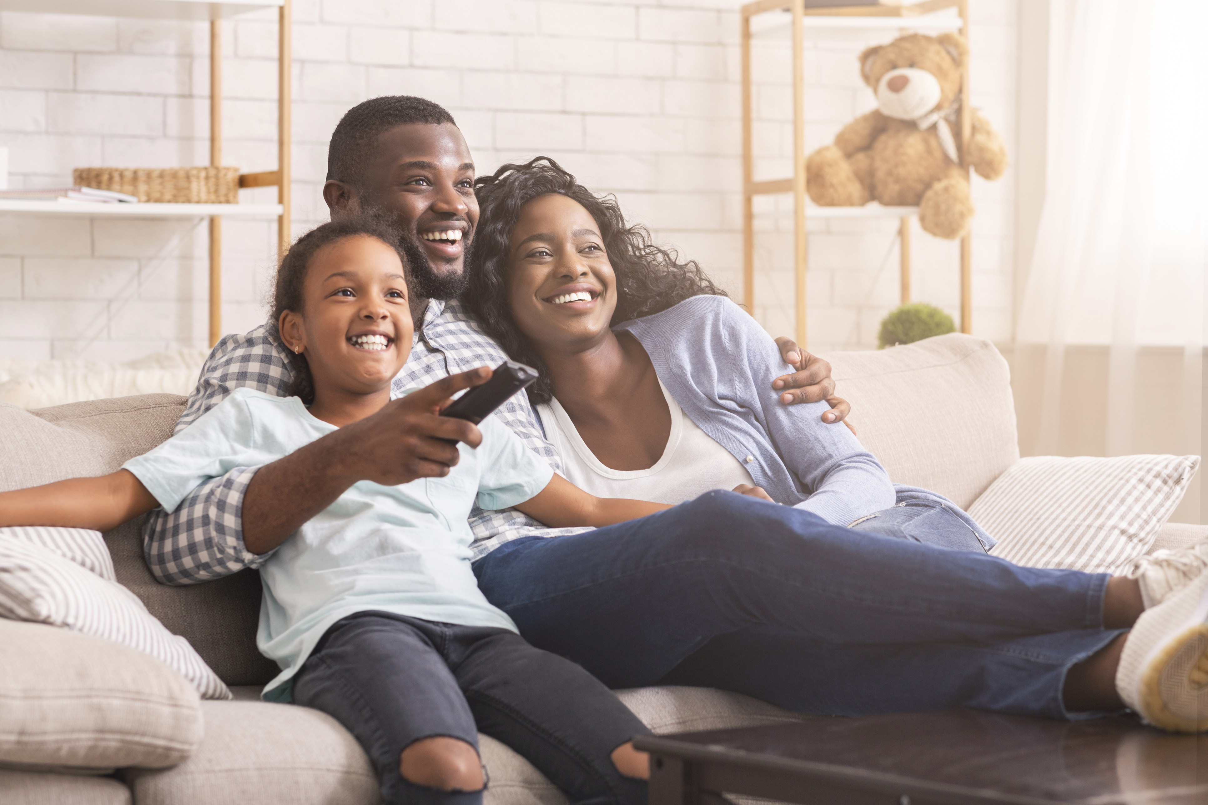Bild einer Familie beim Fernsehen auf Sofa Bild einer Familie beim Fernsehen auf Sofa