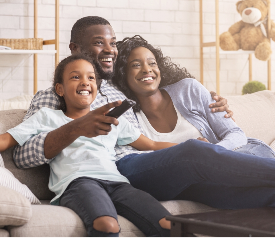 Familie mit Fernbedienung auf Sofa