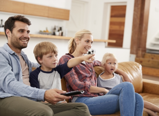 Familie beim Fernsehen auf Sofa Familie beim Fernsehen auf Sofa