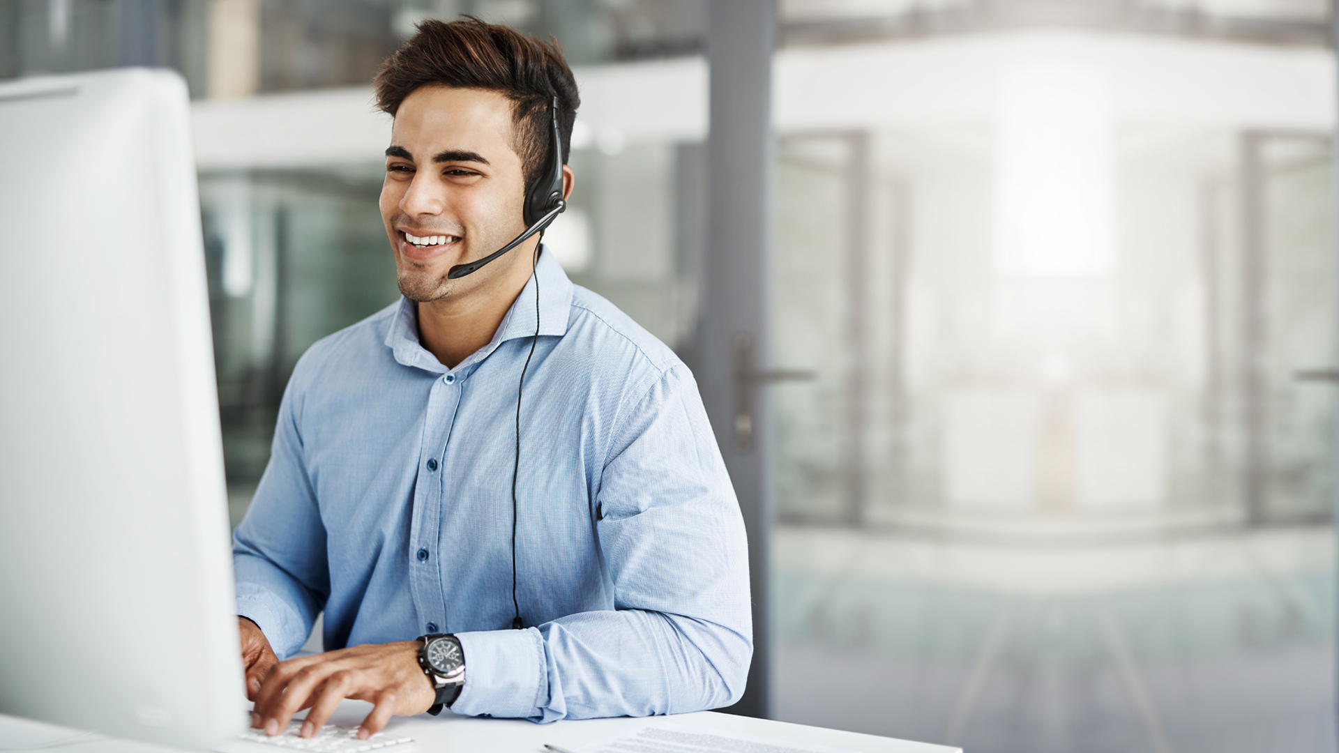 Business Mann mit Headset vor Bildschirm Business Mann mit Headset vor Bildschirm